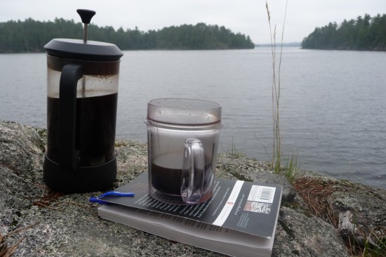 A pot of coffee, a book and a lake